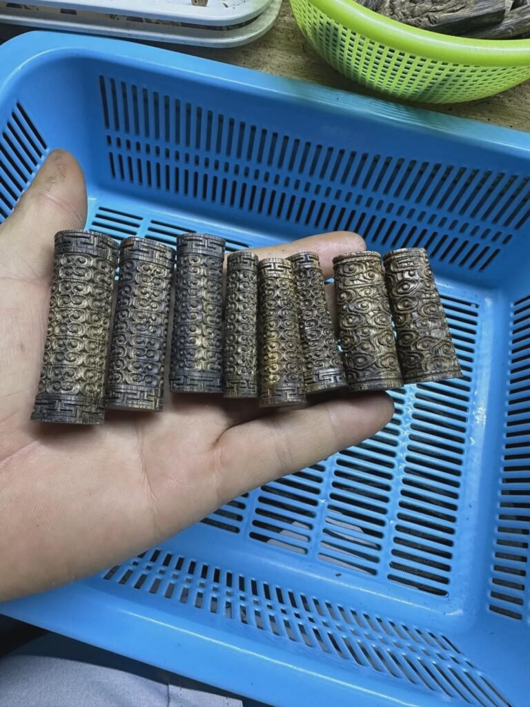 يد تحمل قطعًا خشبية أسطوانية ذات نقوش ظاهرة