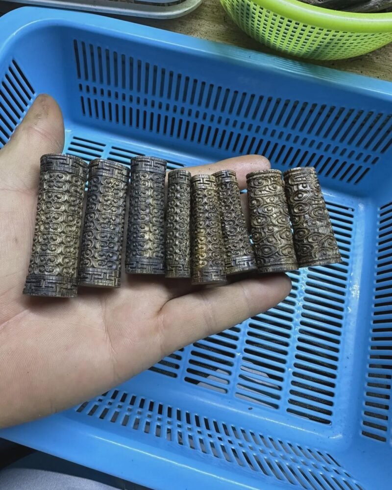 يد تحمل قطعًا خشبية أسطوانية ذات نقوش ظاهرة